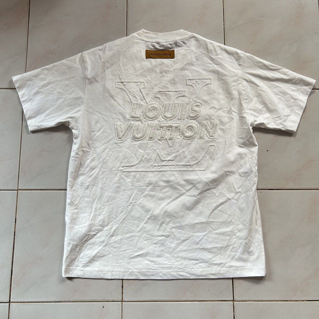 Louis Vuitton White Embroidered Monogram 🔥 (Category: Luxury Apparel) located in Jinoba-an. Submitted by eegiboy (Listing ID 1467650385, Image 1). Description: - Color: White - Material: Comfortable cotton - Design: Large embroidered LV monogram on the back and small LV logo patch on the front chest - Details: Brown leather-look tag at the back collar - Fit: Regular fit with classic crew neck and short sleeves Wts: Lv shirt 🔥 No tags lang po pa
