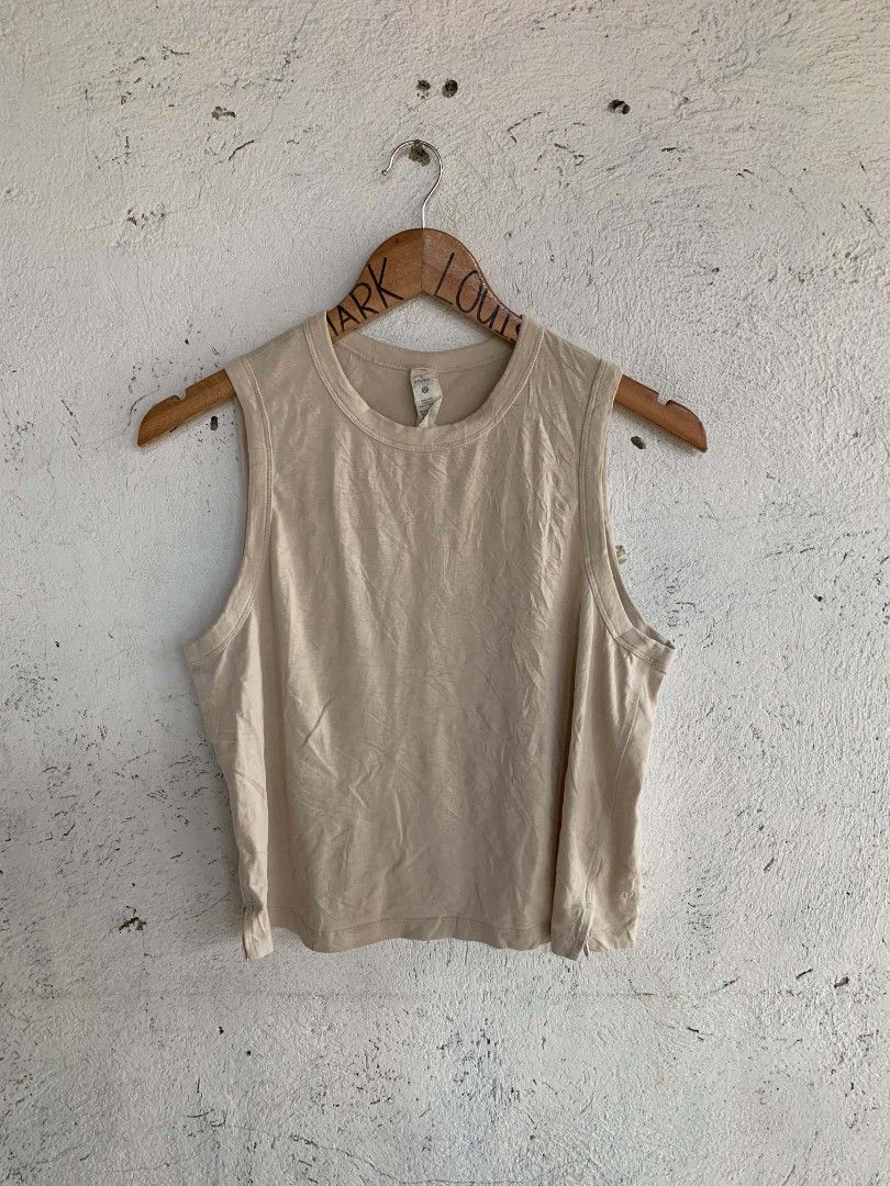 Lululemon Beige Tank Top Size 8 (Category: Sleeveless) located in Manila. Submitted by louiseluch69680 (Listing ID 1467644361, Image 1). Description: - Brand: Lululemon - Style: Sleeveless tank top with round neckline and side slit hem - Color: Neutral beige - Size: 8 (dimes 18x19.5) - Material: Lightweight cotton, lyocell, and linen blend - Details: Subtle embossed Lululemon logo near the bottom corner - Condition: Excellent, versatile for worko