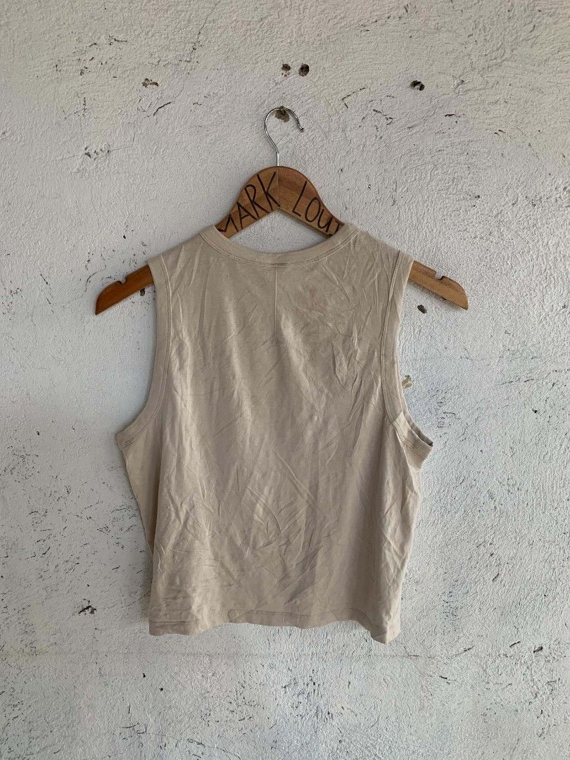 Lululemon Beige Tank Top Size 8 (Category: Sleeveless) located in Manila. Submitted by louiseluch69680 (Listing ID 1467644361, Image 2). Description: - Brand: Lululemon - Style: Sleeveless tank top with round neckline and side slit hem - Color: Neutral beige - Size: 8 (dimes 18x19.5) - Material: Lightweight cotton, lyocell, and linen blend - Details: Subtle embossed Lululemon logo near the bottom corner - Condition: Excellent, versatile for worko
