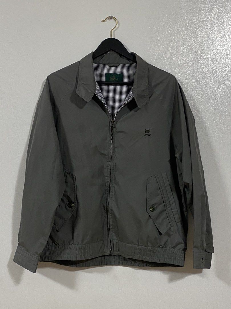 Lynx Vintage Grey Harrington Bomber Jacket (Category: Coats, Jackets and Outerwear) located in Paranaque City. Submitted by pomeloluvr (Listing ID 1467686237, Image 1). Description: - Brand: Lynx - Color: Vintage grey with blue and white gingham check lining - Features: Full zip front, buttoned flap waist pockets, elastic hem and cuffs - Details: Small embroidered Lynx logo on the chest - Condition/Material: Lightweight outer fabric, ideal transi