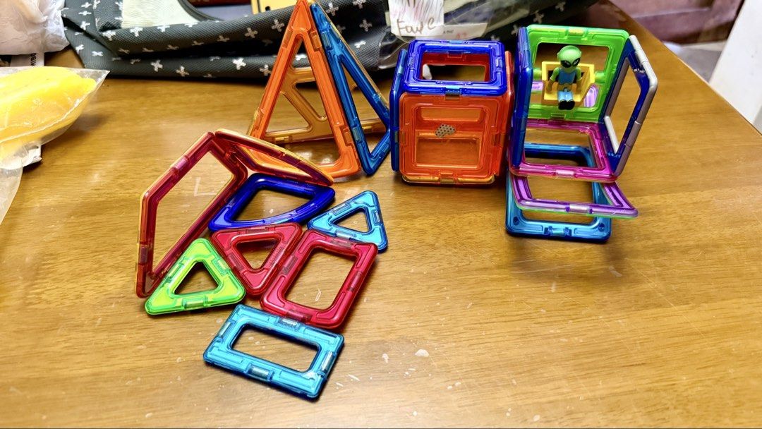 Magnetic Building Blocks Tiles Set with Alien Figure (Category: Lego & Building Sets) located in Pilar. Submitted by faveanyshop (Listing ID 1467621506, Image 2). Description: - Colorful magnetic tiles set including various triangles, squares, and special shapes - Strong and secure magnets for easy 3D building like cubes and pyramids - Includes a bonus small green alien figurine in a yellow chair - Clean condition with all pieces shown in photos 