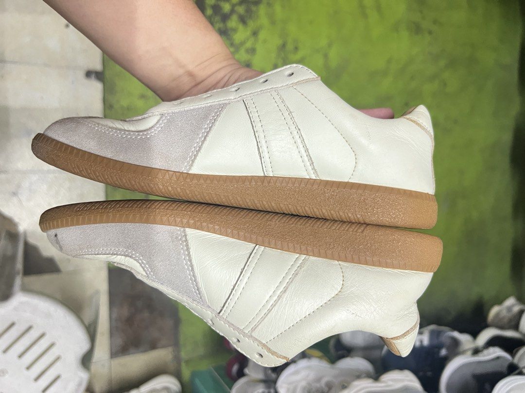 Maison Margiela Replica White Leather Sneakers (Category: Sneakers & Footwear) located in Bulacan. Submitted by thriftstationplus (Listing ID 1467784470, Image 2). Description: - Style: Minimalist German army trainer design in white leather with grey suede toe caps - Sole: Classic gum rubber sole for daily rotation - Condition: Inside leather lining shows visible wear; missing laces - Closure: Lace-up (needs replacement laces) - Profile: Clean lo