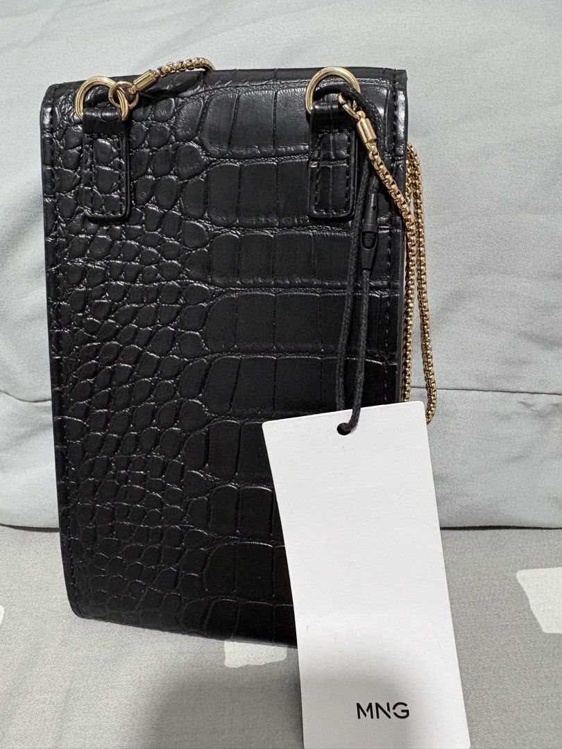 Mango Black Croc Effect Phone Pouch Crossbody Bag (Category: Cross-body Bags) located in Quezon City. Submitted by everything99_ (Listing ID 1467774764, Image 2). Description: - Brand: Mango (Original store tag attached, Model: FUNDA P 75ILEONOR) - Color & Finish: Sleek black with a trendy crocodile texture - Hardware: Elegant gold-tone accents including the front MNG logo and slim chain strap - Closure: Secure flap with a magnetic snap button - 
