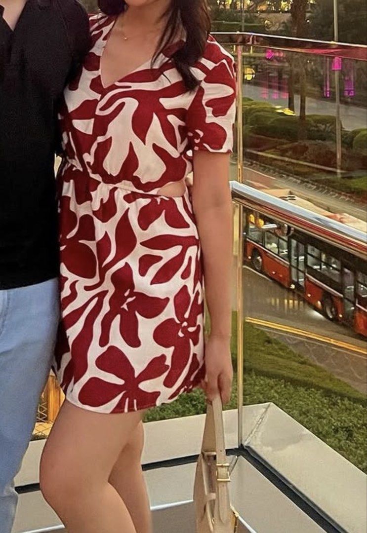 Mango Red Floral Print Cutout Romper Size XS (Category: Rompers) located in Manila. Submitted by m.south (Listing ID 1467736077, Image 3). Description: - Brand: Mango - Size: XS - Design: Red and off-white floral pattern with V-neck and short sleeves - Features: Waist cutouts with adjustable drawstring tie - Material: Lightweight fabric, ideal for warm weather and vacations - Condition: Worn a few times, washed, and well-maintained.