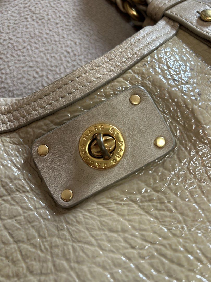 Marc by Marc Jacobs Beige Patent Leather Shoulder Bag (Category: Luxury Bags & Wallets) located in Cavite. Submitted by florabells (Listing ID 1467776006, Image 3). Description: - Brand: Marc by Marc Jacobs - Color/Material: Beige crinkled patent leather with gold-tone hardware - Closure: Front pocket turn-lock closure - Carry Options: Double top handles and a removable strap with engraved clasps - Interior: Lightly patterned fabric lining with a