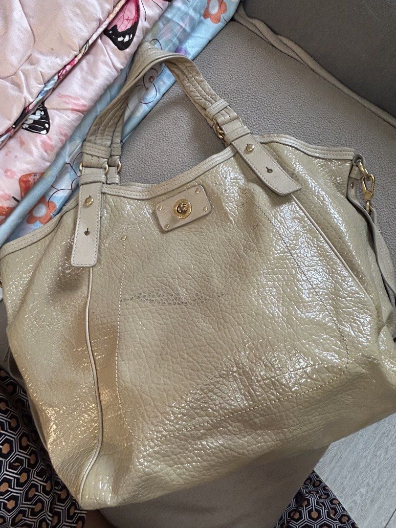 Marc by Marc Jacobs Beige Patent Leather Shoulder Bag (Category: Luxury Bags & Wallets) located in Cavite. Submitted by florabells (Listing ID 1467776006, Image 1). Description: - Brand: Marc by Marc Jacobs - Color/Material: Beige crinkled patent leather with gold-tone hardware - Closure: Front pocket turn-lock closure - Carry Options: Double top handles and a removable strap with engraved clasps - Interior: Lightly patterned fabric lining with a