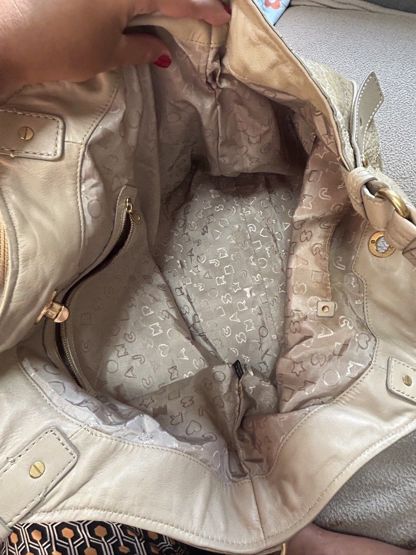 Marc by Marc Jacobs Beige Patent Leather Shoulder Bag (Category: Luxury Bags & Wallets) located in Cavite. Submitted by florabells (Listing ID 1467776006, Image 2). Description: - Brand: Marc by Marc Jacobs - Color/Material: Beige crinkled patent leather with gold-tone hardware - Closure: Front pocket turn-lock closure - Carry Options: Double top handles and a removable strap with engraved clasps - Interior: Lightly patterned fabric lining with a