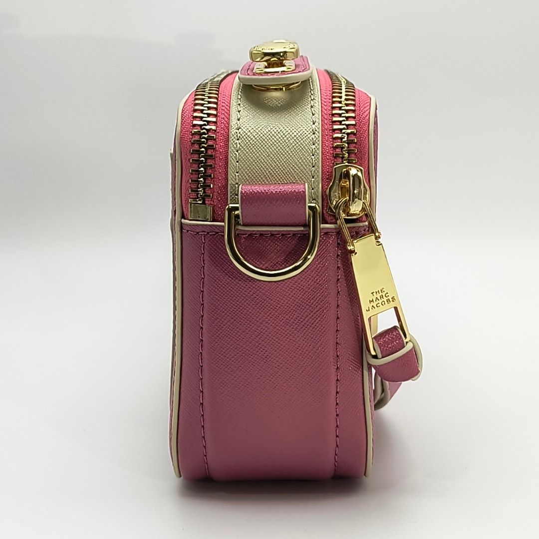 Marc Jacobs The Sure Shot Camera Bag - Pink (Category: Luxury Bags & Wallets) located in Cebu City. Submitted by affordabagss (Listing ID 1467788655, Image 3). Description: Marc Jacobs The Sure Shot camera bag crafted in pink Saffiano leather with contrasting cream and white accents and gold-tone hardware. Features the signature Double J logo, dual top zip compartments, detachable and adjustable woven shoulder strap, and rear slip pocket. Finishe