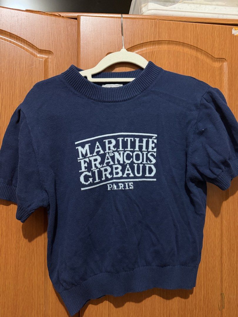 Marithe Francois Girbaud Navy Blue Knit Short Sleeve Top (Category: Blouses) located in Muntinlupa City. Submitted by biancaagbscloset (Listing ID 1467811369, Image 1). Description: - Brand: Marithe Francois Girbaud Paris - Color: Navy blue with distinct white chest logo - Material: Soft, comfortable knit fabric - Design: Ribbed crew neckline, cuffs, and hem - Sleeves: Trendy slightly puffed short sleeves - Style: Casual, chic, and versatile.