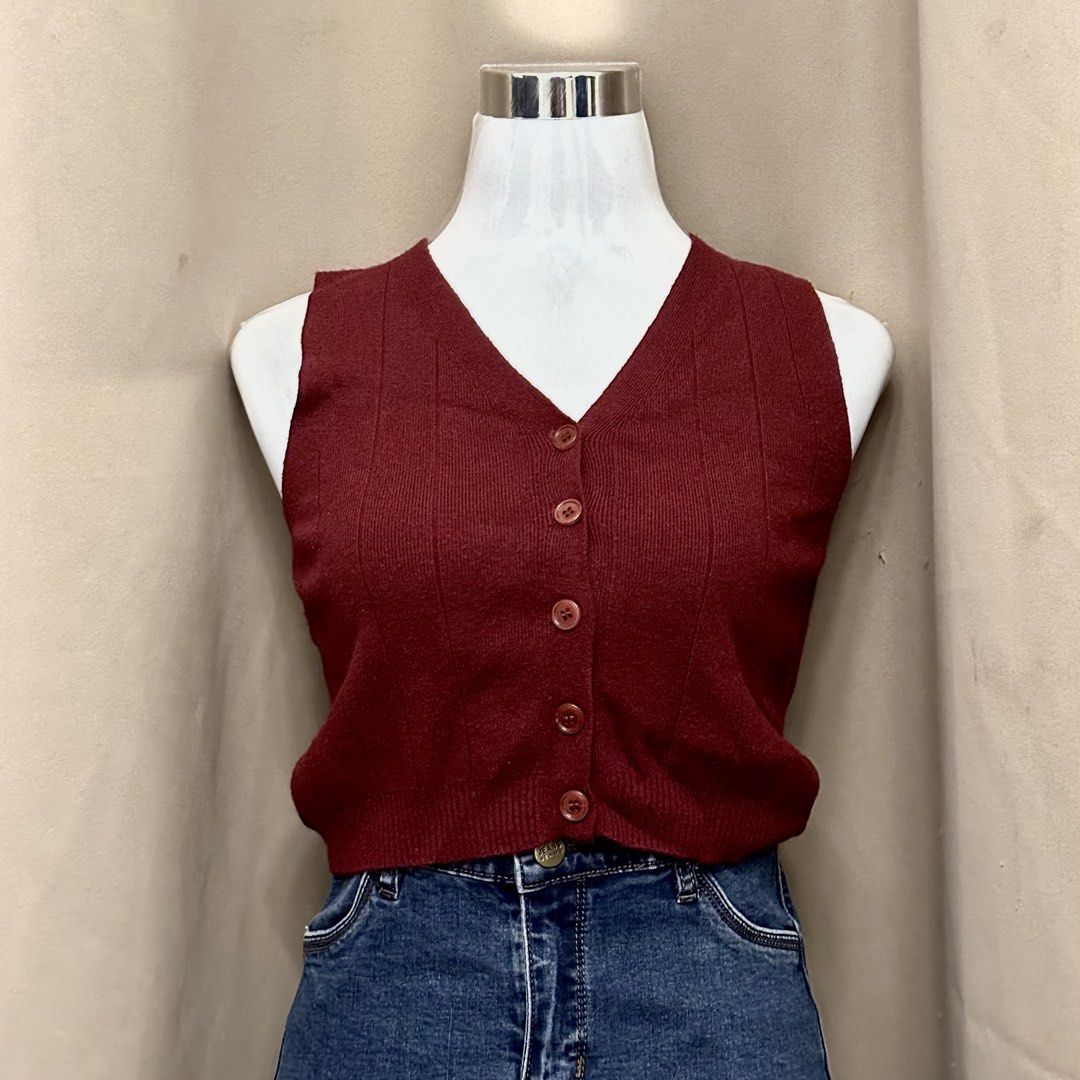 Maroon Knit Button-Up Vest Sleeveless Top (Category: Sleeveless) located in Manila. Submitted by jade_preloved19 (Listing ID 1467672944, Image 1). Description: - Color: Maroon - Material: Soft and lightweight knit fabric - Design: V-neckline with front button closure and matching buttons - Texture: Vertical ribbed pattern - Fit: Cropped length, pairs well with high-waisted jeans - Style: Casual layer for everyday wear.