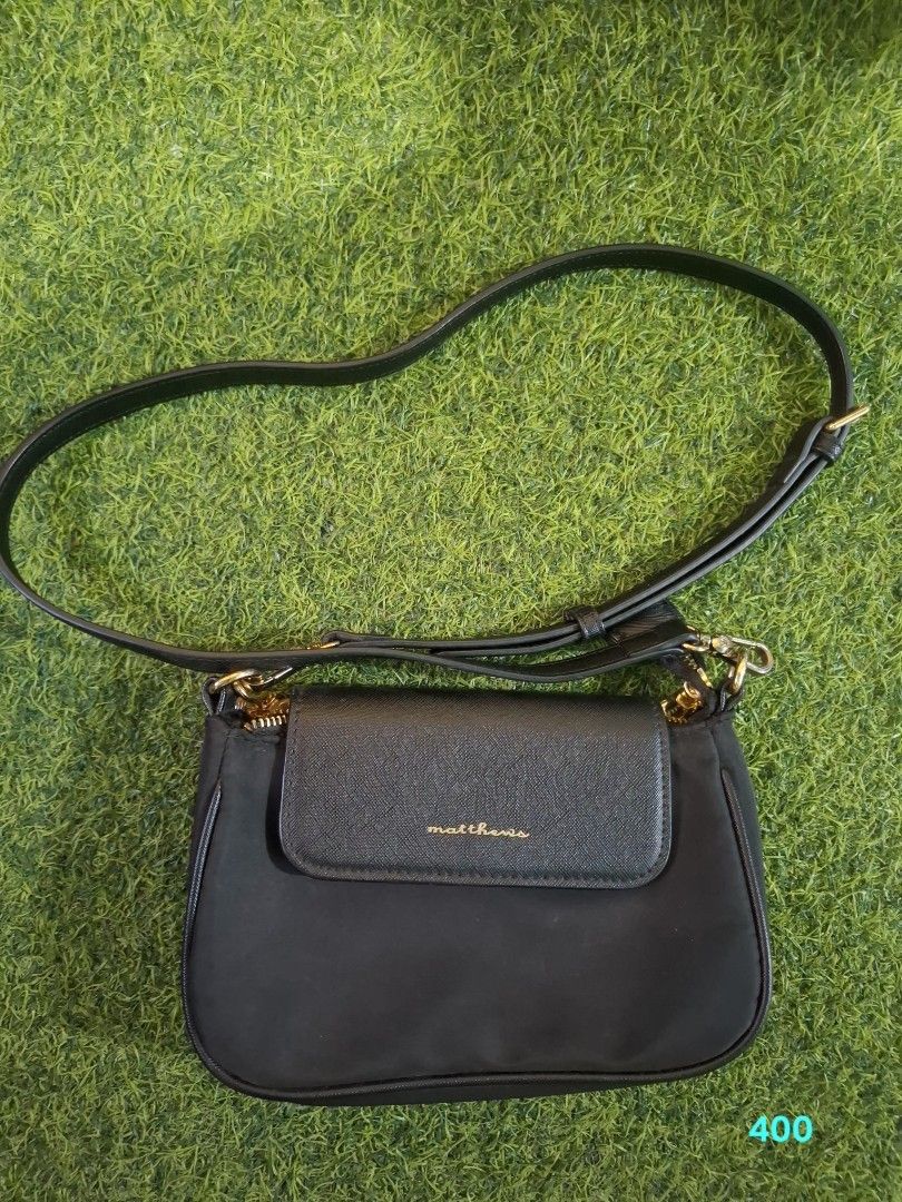 Matthews black nylon crossbody bag (Category: Cross-body Bags) located in Pasay City. Submitted by emilia1102 (Listing ID 1467794479, Image 2). Description: - Brand: Matthews - Color: Classic Black - Material: Soft nylon body with a structured base - Closure: Top zip closure plus a front flap pocket with a textured accent - Hardware: Premium gold-tone details - Strap: Long and fully adjustable - Size: Compact and lightweight, perfect for daily es