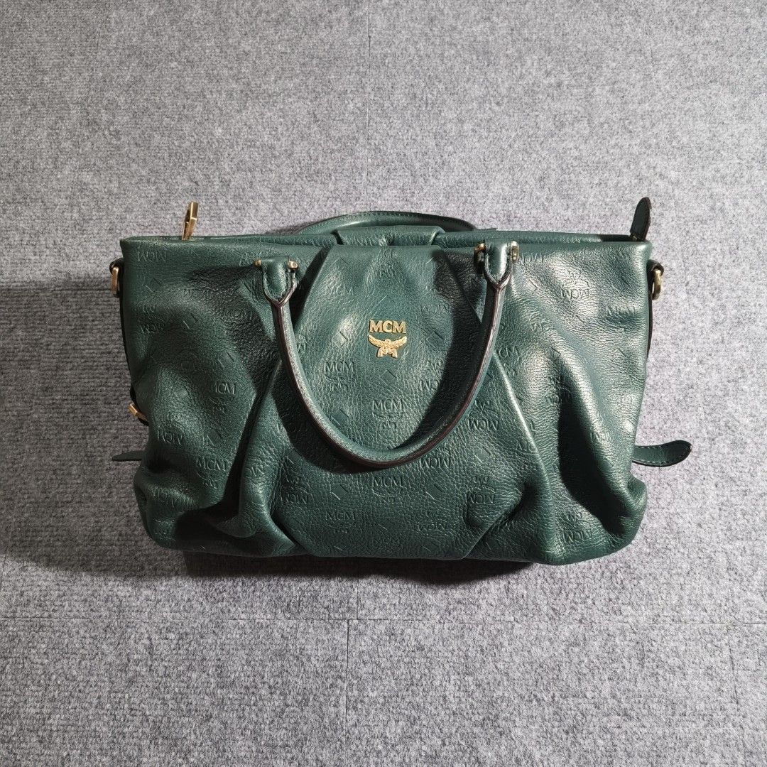 MCM Monogram 2-Way Tote Bag (Category: Luxury Bags & Wallets) located in Antipolo. Submitted by soon2byours_ (Listing ID 1467612565, Image 1). Description: - Brand: MCM - Color: Green - Material: Soft leather with natural grain - Pattern: All-over debossed monogram - Hardware: Gold-tone with engraved branding - Handles: Dual top carry handles with side strap details - Closure: Secure zippered top - Condition: Great everyday carryall with structur