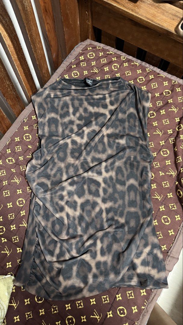 Mibu Sleeveless Leopard Print Mesh Top (Category: Sleeveless) located in Manila. Submitted by backupaccount2 (Listing ID 1467785974, Image 1). Description: Brown and black leopard print top made from a lightweight mesh fabric. Sleeveless cut with a high, slightly draped neckline. Ruching down the sides gives it a fitted shape. Easy to pair with denim jeans for a casual day out. Sizing tag shows size S..