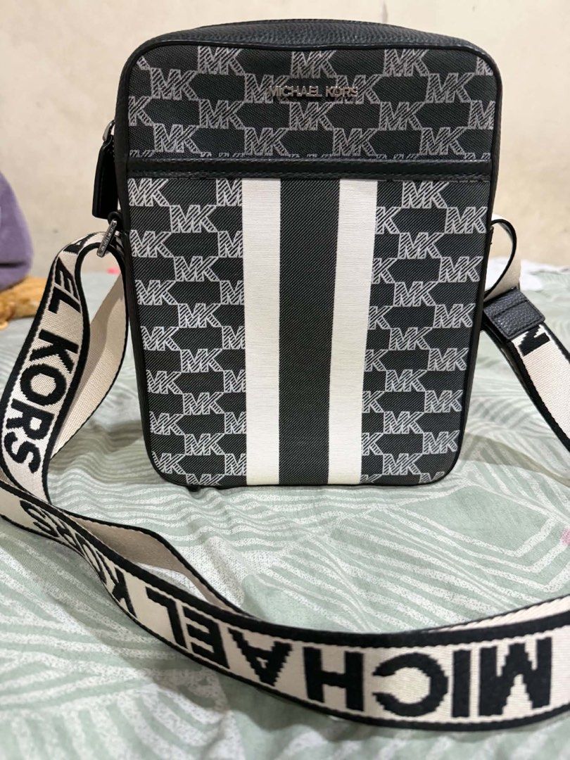 Michael Kors Black White Monogram Crossbody Bag (Category: Luxury Bags & Wallets) located in Pasig City. Submitted by silentbutterfly (Listing ID 1467608094, Image 2). Description: - Brand: Michael Kors - Material: Monogram canvas with textured black leather trim - Design: Classic black and white monogram with a bold front stripe - Strap: Adjustable canvas shoulder strap featuring bold MK lettering - Pockets: Convenient front zipper pocket for qu