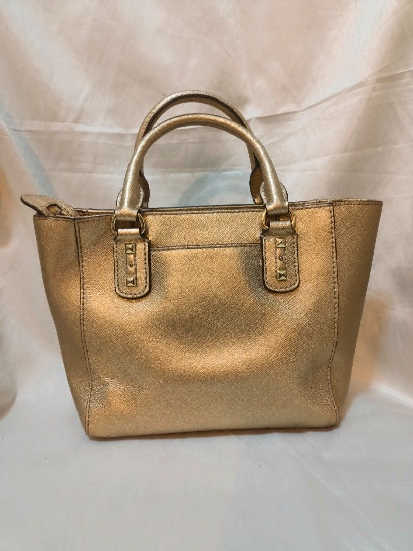 Michael Kors Gold Studded Tote Handbag (Category: Luxury Bags & Wallets) located in Manila. Submitted by preloved439 (Listing ID 1467234876, Image 2). Description: - Authentic Michael Kors Sandrine - Structured design with durable dual top handles - Stylish gold-tone pyramid studs along the front - Open top with a convenient zipped main compartment - Compact yet spacious enough for daily essentials - Crafted from clean, durable Saffiano-style lea