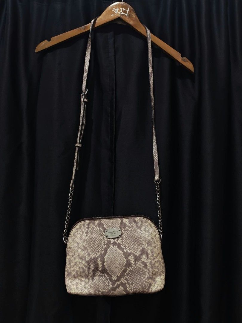 Michael Kors Python Print Crossbody Bag (Category: Cross-body Bags) located in Baguio. Submitted by solo_ukay (Listing ID 1467786916, Image 1). Description: Michael Kors crossbody bag in a python snakeskin print. Silver-toned hardware plaque on the front with Michael Kors Est. 1981 lettering. Zip-top closure leading to a branded fabric interior lining with a slip pocket. Adjustable strap with chain links on the lower sections. Shows some interior