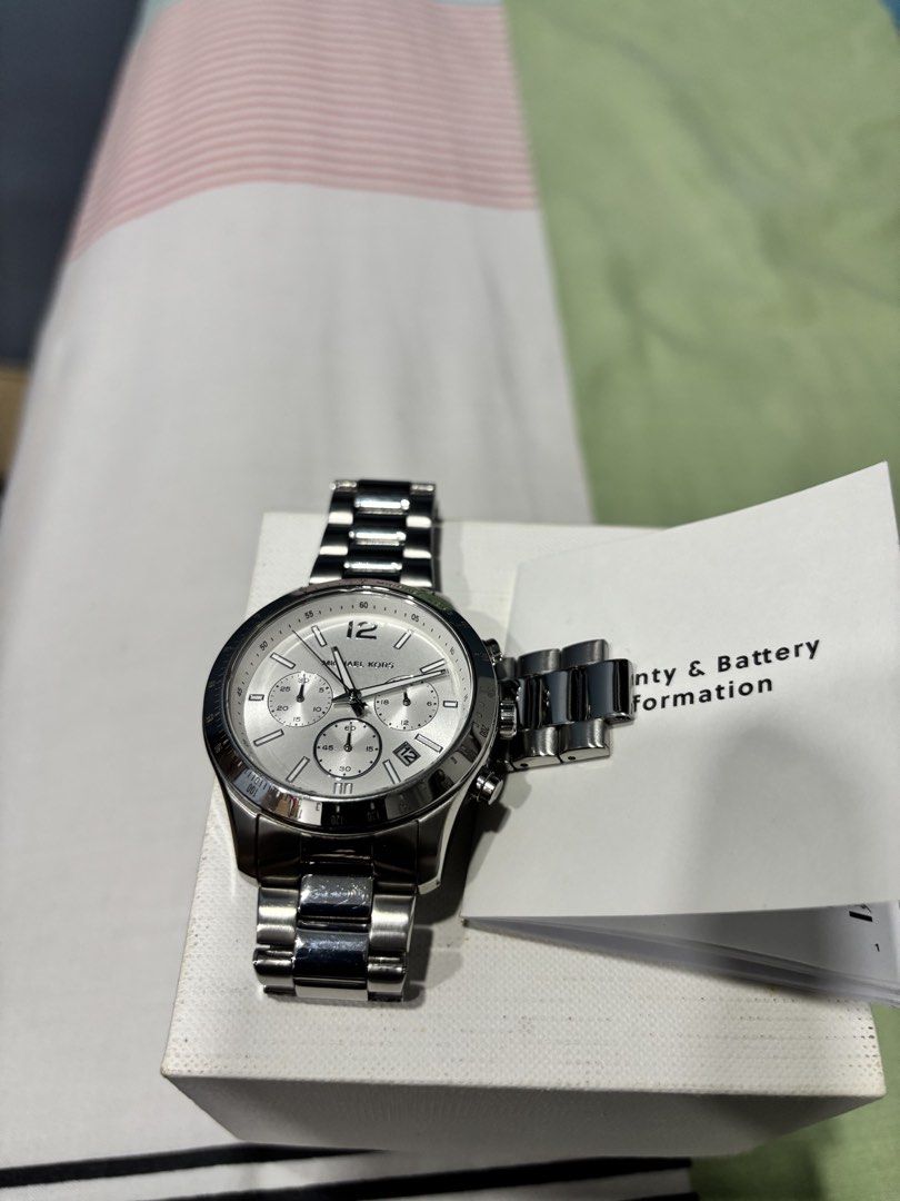 Michael Kors Silver Chronograph Watch (Category: Men's Watches) located in Tarlac. Submitted by aldrin328 (Listing ID 1467738072, Image 2). Description: - Brand: Michael Kors - Color/Finish: Silver-tone stainless steel with polished finish - Dial: Textured dial with chronograph subdials and date display - Bezel: Tachymeter bezel - Closure: Secure deployment clasp - Condition: Clean crystal, overall polished finish - Inclusions: Original box, warr
