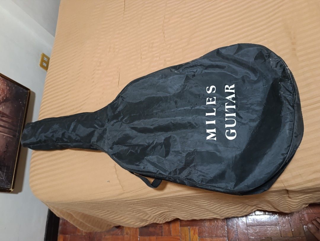 Miles Classical Acoustic Guitar with Bag (Category: Musical Instruments) located in Quezon City. Submitted by kuruma_13 (Listing ID 1467641073, Image 3). Description: - Brand: Miles classical acoustic guitar - Material/Finish: Natural wood finish with decorative soundhole rosette - Strings: Nylon strings installed (gentle on the fingers) - Inclusion: Comes with a matching black gig bag for safe storage and transport - Condition/Use: Perfect for b