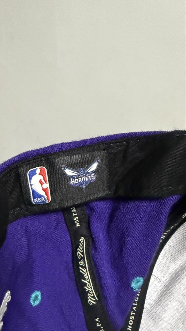 Mitchell & Ness Charlotte Hornets Snapback Cap (Category: Caps & Hats) located in Quezon City. Submitted by kobeeeee_12 (Listing ID 1467737405, Image 3). Description: - Brand: Mitchell & Ness - Team: Charlotte Hornets - Design: Purple crown with teal and blue gradient flat brim featuring a dot pattern - Details: Embroidered Hornets logo on the front, branded interior taping - Closure: Adjustable blue snapback - Condition: Excellent, clean interio