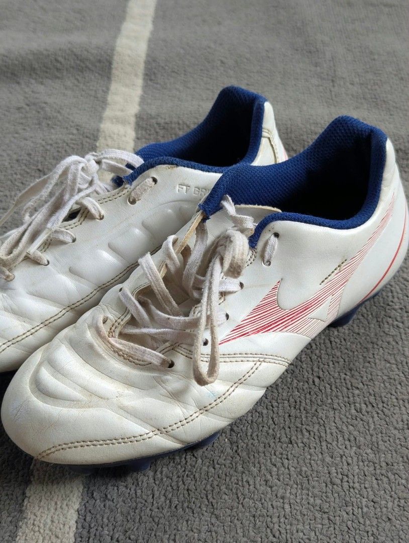 Mizuno Rebula Cup eu36 (Category: Sneakers) located in Bacolod City. Submitted by closetcleanupbcd (Listing ID 1467635148, Image 3). Description: - Brand: Mizuno soccer boots - Color: White with blue lining and red branding details - Tech: FT Grip upper technology for better ball control - Condition: Minor dirt marks and scuffs from pitch use; soles and studs are still 100% intact - Inclusions: Original white laces - Best for: Training sessions o