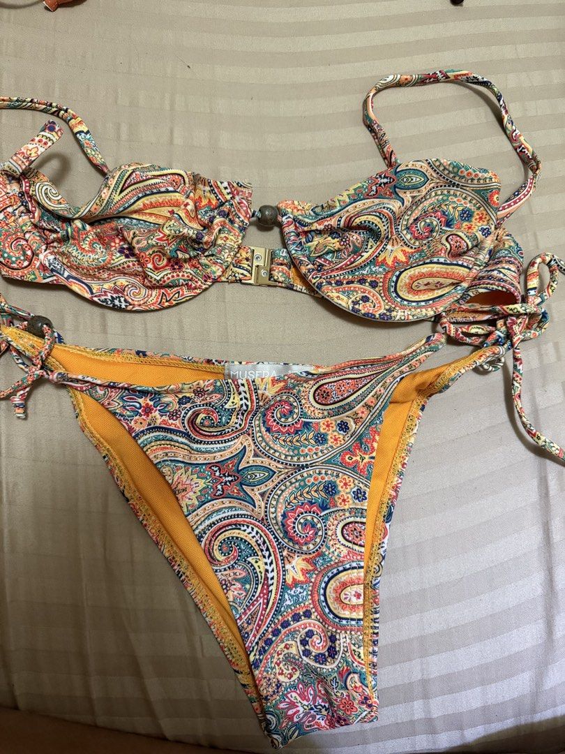 Musera Paisley Print Bikini Set (Category: Bikinis & Swimsuits) located in Marikina City. Submitted by lmgl30 (Listing ID 1467741125, Image 2). Description: - Brand: Musera - Design: Vibrant multi-color paisley print with bright yellow lining - Top: Underwire support, front clasp closure, and adjustable straps - Bottoms: Adjustable side ties adorned with cute bead accents - Ideal for: Beach trips, pool parties, and tropical getaways USED ONCE ONL