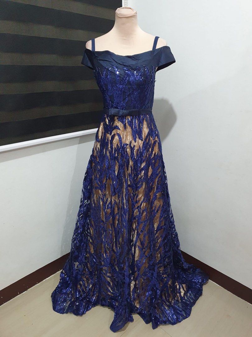 Navy blue and gold sequin evening gown (Category: Evening dresses & gowns) located in Makati City. Submitted by esila.essentials (Listing ID 1467718344, Image 2). Description: FOR RENT - Color: Navy blue and gold with sparkly leaf-patterned sequins - Style: Cold shoulder with thin straps, satin bodice, and thin bow belt at the waist - Length: Floor-length evening gown - Condition: Flawless, worn only once and dry cleaned immediately - Ready to we