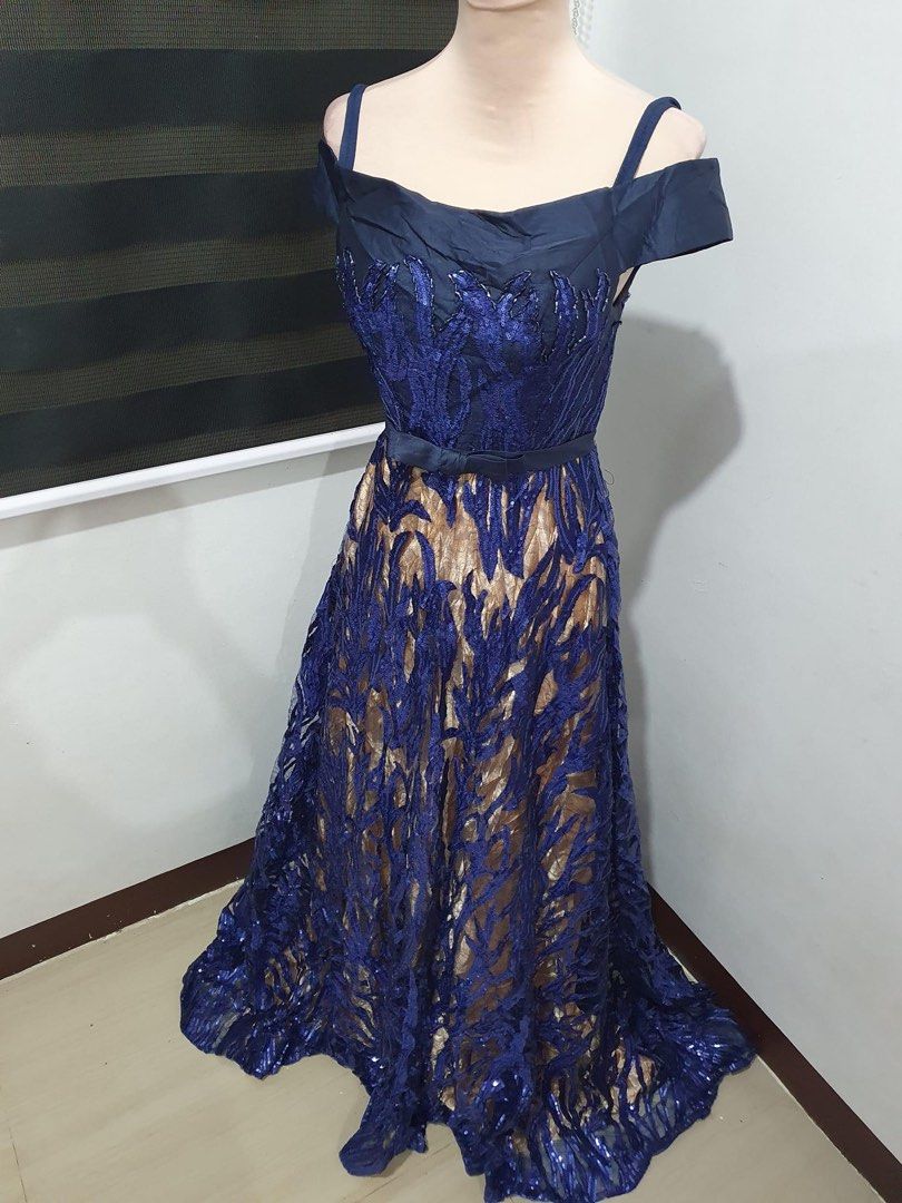 Navy blue and gold sequin evening gown (Category: Evening dresses & gowns) located in Makati City. Submitted by esila.essentials (Listing ID 1467718344, Image 3). Description: FOR RENT - Color: Navy blue and gold with sparkly leaf-patterned sequins - Style: Cold shoulder with thin straps, satin bodice, and thin bow belt at the waist - Length: Floor-length evening gown - Condition: Flawless, worn only once and dry cleaned immediately - Ready to we