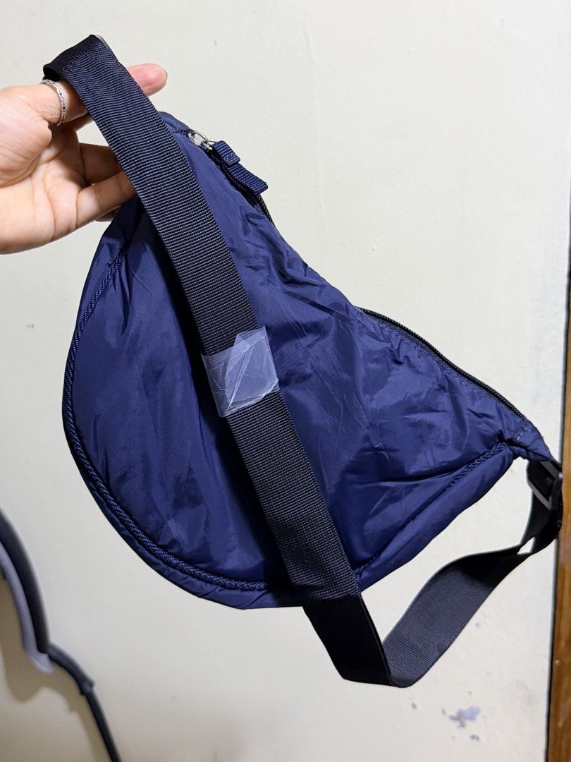 Navy Blue Crescent Nylon Sling Bag (Category: Cross-body Bags) located in Paete. Submitted by skydruemadison (Listing ID 1467719997, Image 1). Description: - Color: Navy blue - Material: Lightweight nylon - Style: Trendy crescent shape with smooth curved zipper - Strap: Adjustable black strap (still wrapped in protective plastic) - Capacity: Roomy main compartment, easily fits phone, wallet, and keys - Use: Great for daily errands and hands-free 