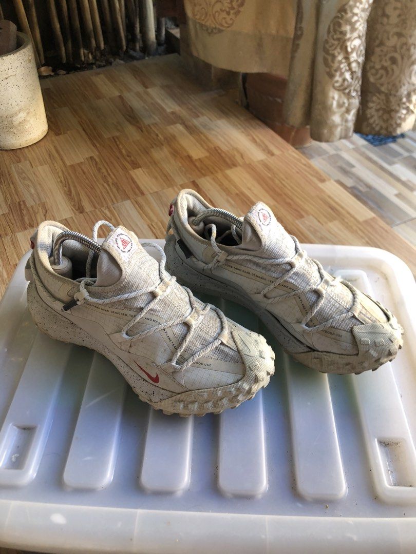 Nike ACG Mountain Fly Low White (Category: Sneakers) located in Tarlac. Submitted by jds_thrift (Listing ID 1467726204, Image 2). Description: - Model: Nike ACG Mountain Fly Low - Colorway: White and Beige - Upper: Durable mesh with rope lacing system - Protection: Rugged rubber toe cap for extra outdoor traction - Sole: Speckled midsole - Details: Red Nike swoosh branding and ACG logo patch on tongue - Condition: Ready for trails or daily wear.