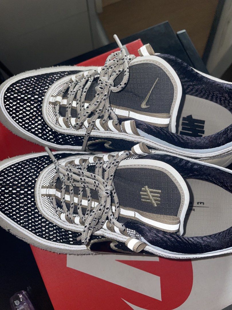 Nike Air Zoom Spiridon x UNDEFEATED Phantom (Category: Sneakers) located in Pasig City. Submitted by blu_papellero (Listing ID 1467690217, Image 2). Description: - Brand: Nike x UNDEFEATED - Model: Air Zoom Spiridon 'Phantom' - Colorway: Black mesh upper with beige suede overlays - Features: Reflective laces, UNDEFEATED tongue branding, and blue heel pull tab - Packaging: Comes with original Nike shoebox.