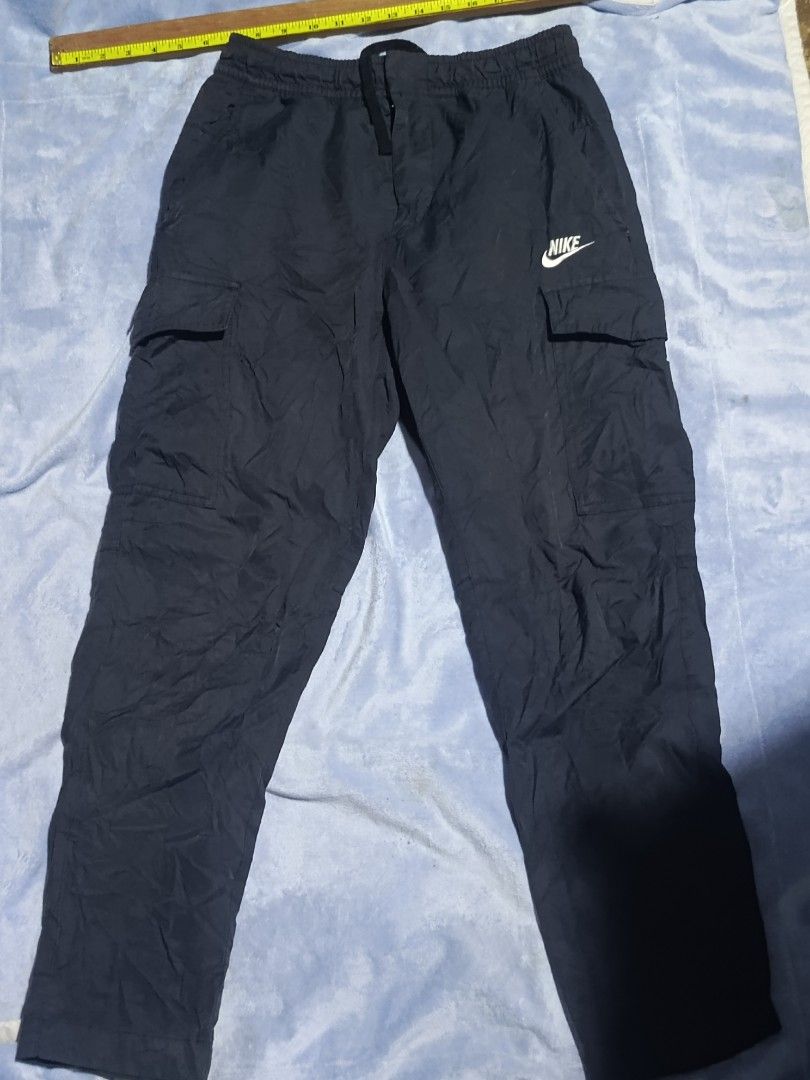 Nike Cargo Pants Dark Grey Medium (Category: Joggers) located in City of Isabela. Submitted by warmbird.d06e6f (Listing ID 1467637123, Image 1). Description: - Brand: Nike - Color: Dark Grey - Size: Medium - Material: Cotton, nylon, and polyester blend (Made in Vietnam) - Waistband: Elastic with secure drawstring - Pockets: Two functional side cargo pockets with printed Nike logo - Best for: Casual wear, workouts, and daily errands - Condition: B