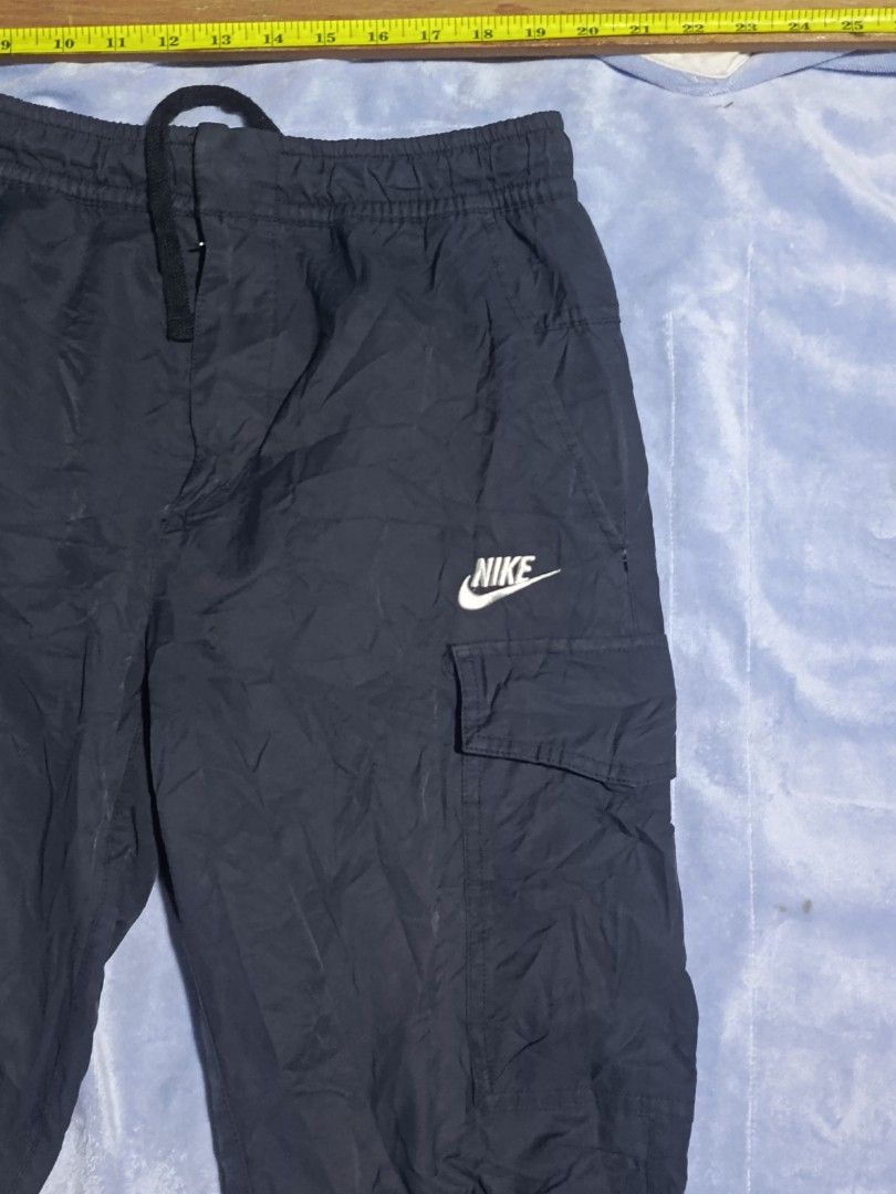 Nike Cargo Pants Dark Grey Medium (Category: Joggers) located in City of Isabela. Submitted by warmbird.d06e6f (Listing ID 1467637123, Image 2). Description: - Brand: Nike - Color: Dark Grey - Size: Medium - Material: Cotton, nylon, and polyester blend (Made in Vietnam) - Waistband: Elastic with secure drawstring - Pockets: Two functional side cargo pockets with printed Nike logo - Best for: Casual wear, workouts, and daily errands - Condition: B