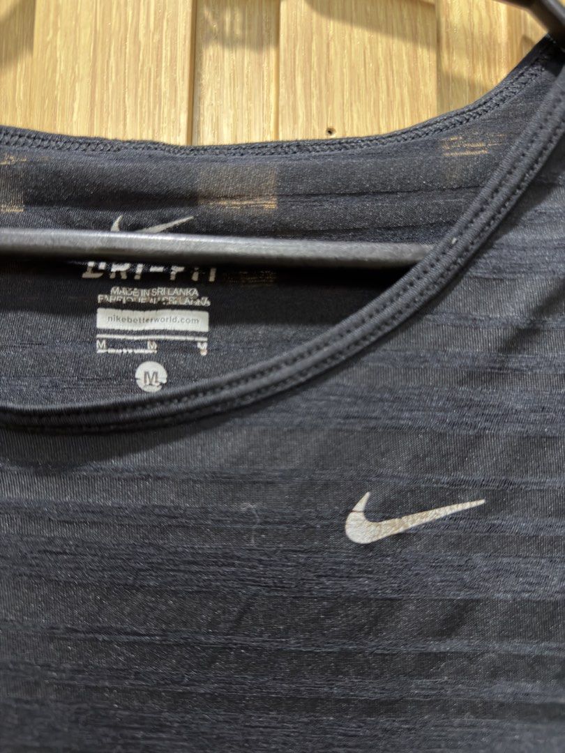 Nike Dri-FIT Black Striped Workout Top Size M (Category: Activewear) located in Bacoor. Submitted by preloved_with_love_ (Listing ID 1467609166, Image 2). Description: - Brand: Nike - Style: Dri-FIT athletic top with horizontal stripes - Size: Medium (Made in Sri Lanka) - Material: Lightweight and slightly sheer fabric - Design: Scoop neckline, short sleeves, curved hem, and iconic Nike swoosh logo - Condition: Excellent, pre-loved/new - Perfect 