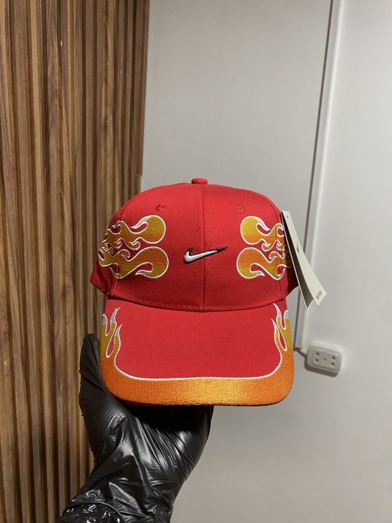 Nike Flame Red Hat Cap with Ferrari Tag (Category: Caps & Hats) located in Caloocan City. Submitted by heatedcaps4425 (Listing ID 1467800479, Image 1). Description: - Brand new with original store tags still attached - Bright red Nike Dri-FIT cap with flame embroidery across the front and sides - Curved brim featuring a stylish orange gradient accent - Rare Ferrari interior tag attached - Adjustable metal strap closure with an embroidered Swoosh 