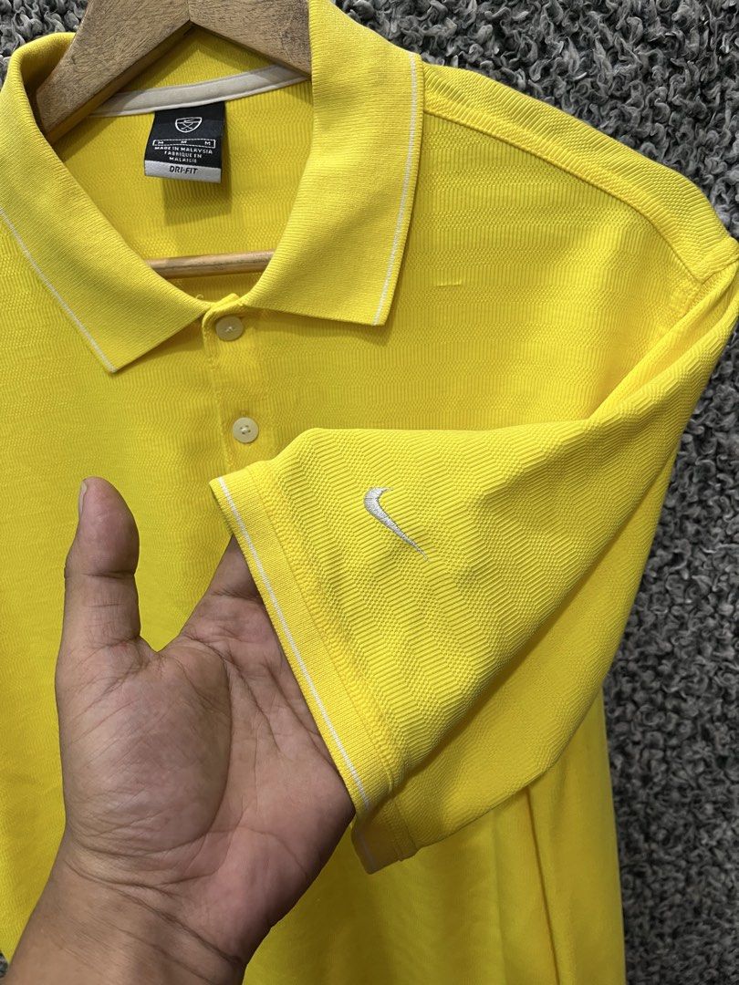 Nike Golf Dri-FIT Polo | Size M (Category: Tshirts & Polo Shirts ) located in General Trias. Submitted by zrchustle.604 (Listing ID 1467827093, Image 2). Description: Nike Golf Dri-FIT Polo Shirt featured in a bright yellow colorway. This specific athletic style features a traditional short-sleeve construction, a three-button placket, subtle piping details along the collar and cuffs, and the classic embroidered Nike Swoosh trademark logo on the s