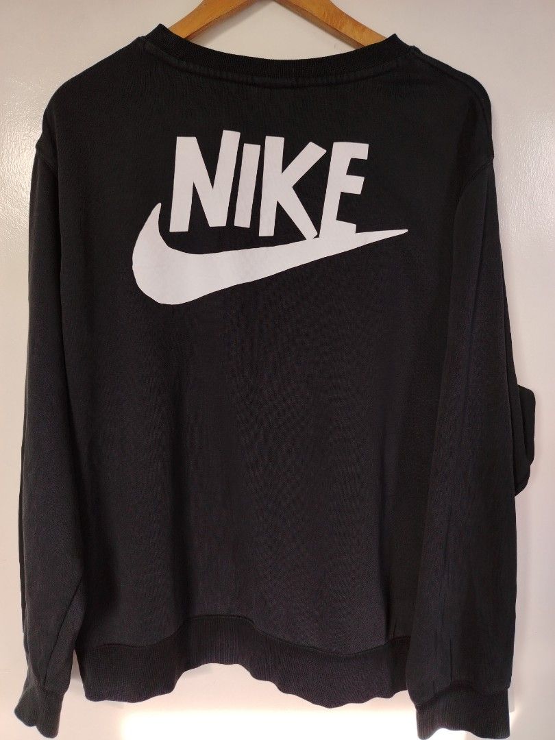Nike Graphic Print Black Sweatshirt XXL (Category: Coats, Jackets and Outerwear) located in Manila. Submitted by zyclothing03 (Listing ID 1467688849, Image 3). Description: - Brand: Nike - Color: Black - Size: XXL - Origin: Made in India - Design: Small sun & rainbow graphic on chest, large white Nike swoosh & lettering on back - Features: Ribbed collar, cuffs, and hem - Condition: Clean overall condition, well-maintained.