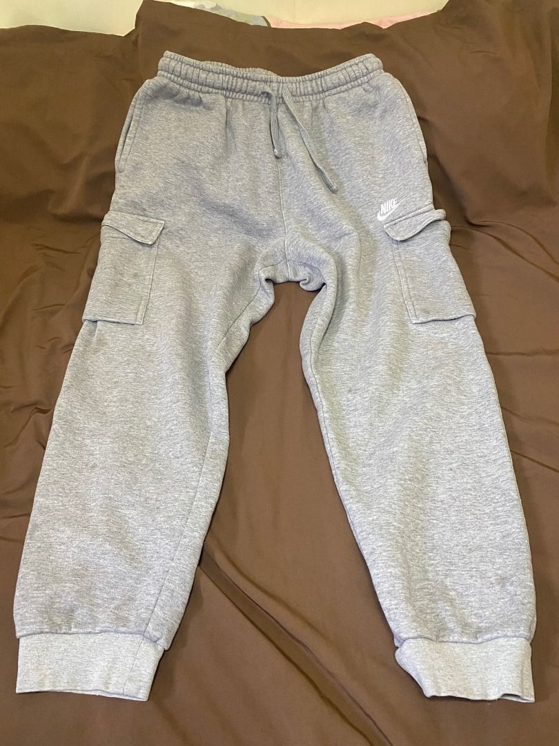 Nike Grey Cargo Sweatpants (Category: Joggers) located in San Pablo. Submitted by kisha_santonia (Listing ID 1467668434, Image 1). Description: - Brand: Nike - Style: Cargo sweatpants with side utility pockets - Color: Grey with embroidered white Nike logo - Size: L (Tag attached) - Measurements: Total length approx. 34 inches, ankle opening approx. 5 inches across - Material: Soft cotton fleece inside for maximum comfort - Features: Drawstring w