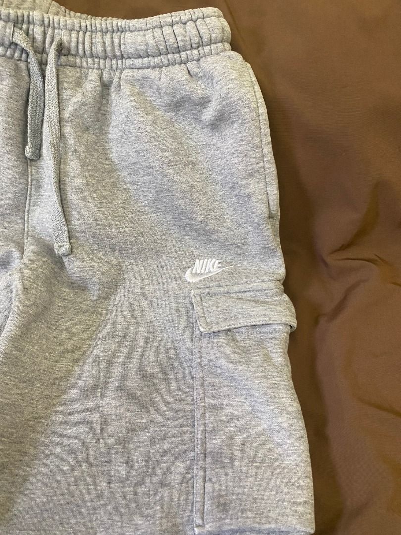 Nike Grey Cargo Sweatpants (Category: Joggers) located in San Pablo. Submitted by kisha_santonia (Listing ID 1467668434, Image 2). Description: - Brand: Nike - Style: Cargo sweatpants with side utility pockets - Color: Grey with embroidered white Nike logo - Size: L (Tag attached) - Measurements: Total length approx. 34 inches, ankle opening approx. 5 inches across - Material: Soft cotton fleece inside for maximum comfort - Features: Drawstring w