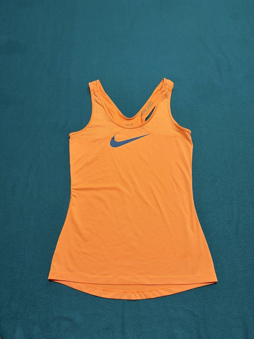 Nike Pro Orange Athletic Tank Top Size S (Category: Activewear) located in Guihulngan. Submitted by fbthriftgoodsniace (Listing ID 1467682925, Image 1). Description: Bright orange Nike Pro athletic tank top. Large blue swoosh logo on the front. Racerback design with Nike Pro branding on the strap. Size S tag printed inside. Pit to pit measures around 14 inches. Total length is about 26 inches. Made in El Salvador..