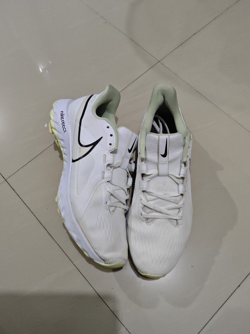 Nike React White Spikeless golfshoes (Category: Sneakers) located in Davao. Submitted by judelabust72026 (Listing ID 1467748071, Image 2). Description: - Brand: Nike React Turf Football Boots - Colorway: White with black swoosh logos and neon yellow soles/heel accents - Closure: Lace-up with centered Nike branding - Condition: Uppers are clean overall; outer soles show minor dirt from previous turf play - Performance: Responsive React cushioning,