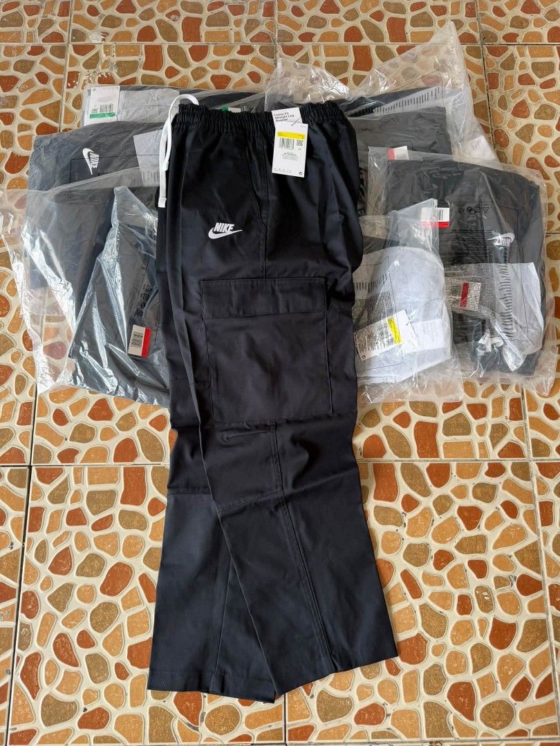 Nike woven cargo pants (Category: Joggers) located in Manila. Submitted by ryanjoseph94468 (Listing ID 1467756266, Image 1). Description: - Item: Brand new Black Nike Cargo Pants - Fit: Loose fit with a straight leg cut - Waistband: Elastic with an adjustable white drawstring - Pockets: Large cargo pockets on the thighs - Branding: White Nike logo embroidery near the pocket - Condition: Brand new with retail tags attached in original plastic pack