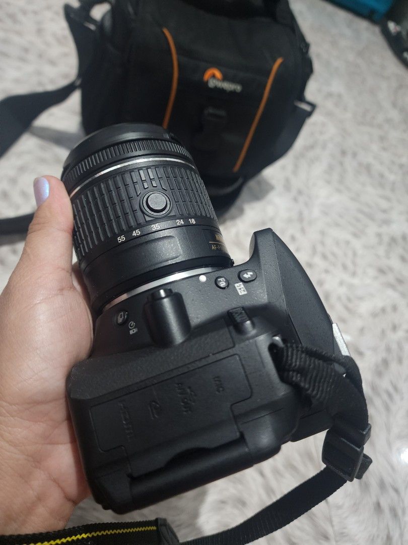 Nikon D5300 Camera with Lens and Lowepro Bag (Category: Cameras) located in Valenzuela. Submitted by sunshinebucud (Listing ID 1467660749, Image 3). Description: - Nikon DSLR camera body and zoom lens ready for shooting - Includes Nikon neck strap and padded Lowepro shoulder bag - Fully functional setup with clean optics and responsive buttons - Battery door is completely intact - Minor cosmetic scuffs around the bottom tripod mount plate.