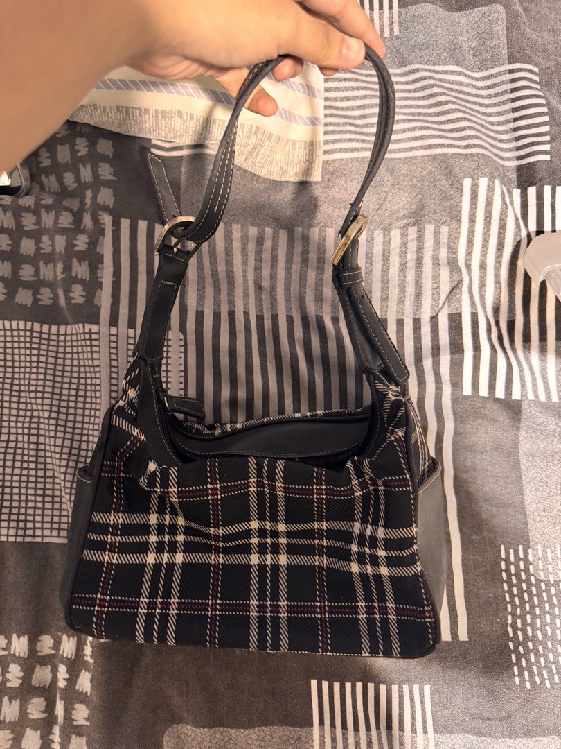Nine West Plaid Shoulder Bag (Category: Shoulder Bags) located in Manila. Submitted by champagnemam1 (Listing ID 1467685464, Image 1). Description: - Brand: Nine West - Design: Classic black, white, and red plaid pattern - Straps: Dark straps with adjustable buckles on both sides - Closure: Secure zip-top closure - Interior: Features a small inner brand tag near the zipper - Size: Compact and lightweight, ideal for effortless all-day use - Condit