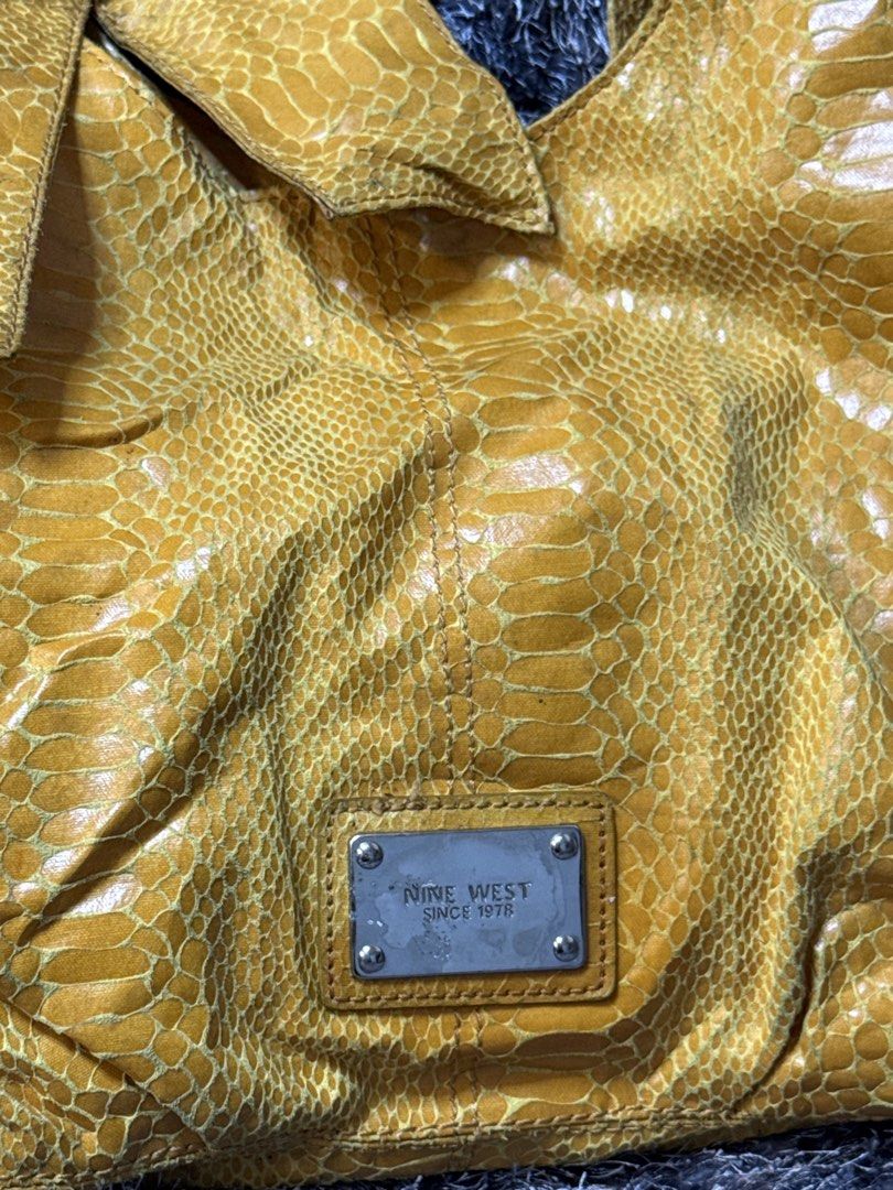 Nine West Yellow Snakeskin-embossed bag (Category: Shoulder Bags) located in Manila. Submitted by sophia_cantos23 (Listing ID 1467640474, Image 2). Description: Vintage Nine West mustard yellow hobo shoulder bag featuring a glossy snakeskin-embossed texture, a soft slouchy silhouette, and a statement bow detail on the front. Complete with a signature Nine West metal logo plaque and shoulder straps, this bag adds a bold vintage touch to any outfit