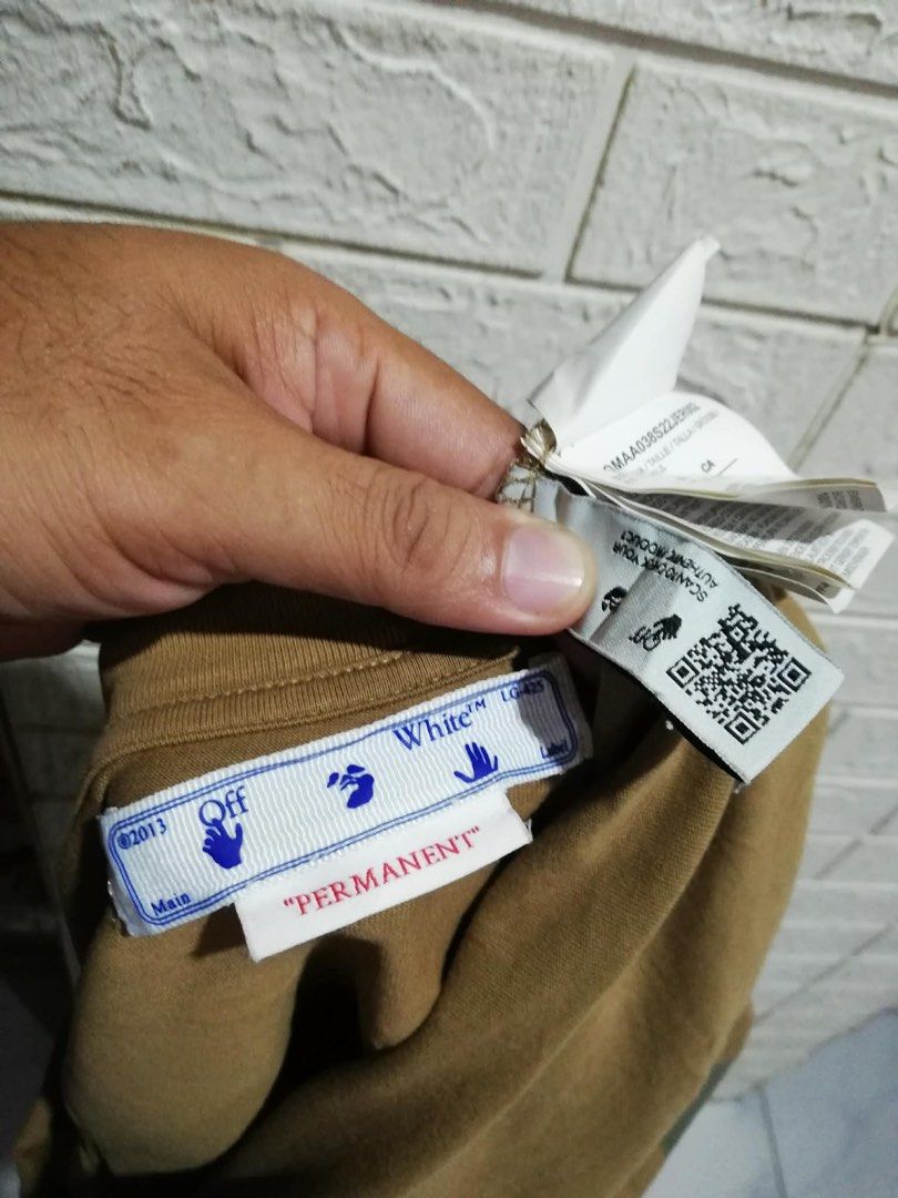 Off-White Brown Permanent T-Shirt Size S (Category: Tshirts & Polo Shirts ) located in Rizal. Submitted by tiangarcia02 (Listing ID 1467761367, Image 3). Description: - Brand: Off-White (Permanent Collection) - Color: Brown - Size: Small (S) - Material: 100% Cotton with rib collar - Fit: Standard crew neck, short sleeve - Design: Small chest logo text, large iconic diagonal stripes graphic on the back - Model Code: OMAA038S22JER002 - Condition: 1