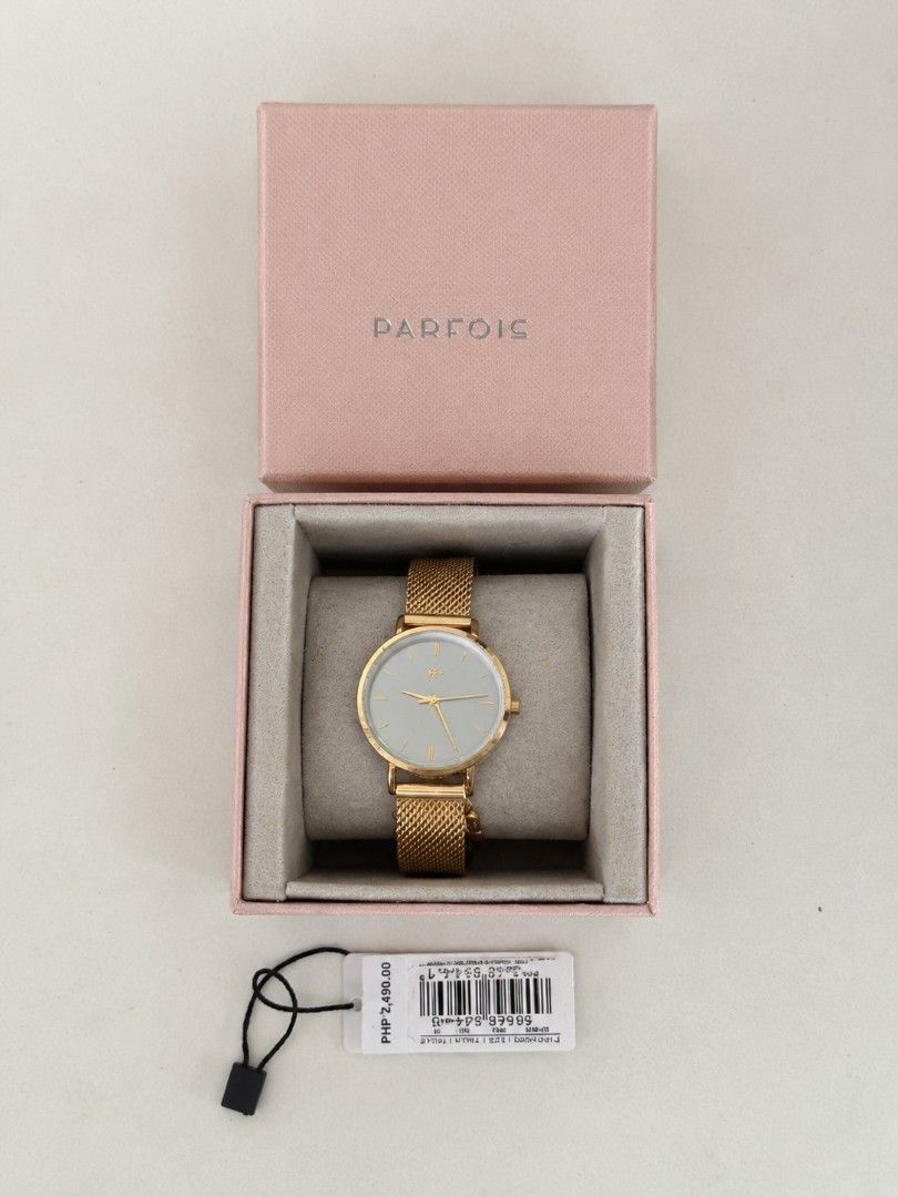 PARFOIS Gold Mesh Strap Watch with Charm (Category: Women's Watches) located in Manila. Submitted by maxinesotto (Listing ID 1467612657, Image 1). Description: Gold watch from Parfois, mesh strap style. Includes a small rhinestone charm hanging near the case. Back is stainless steel. Comes packed inside its original pink presentation box with price tag attached. Simple, clean minimalist face design in gold and white tones..