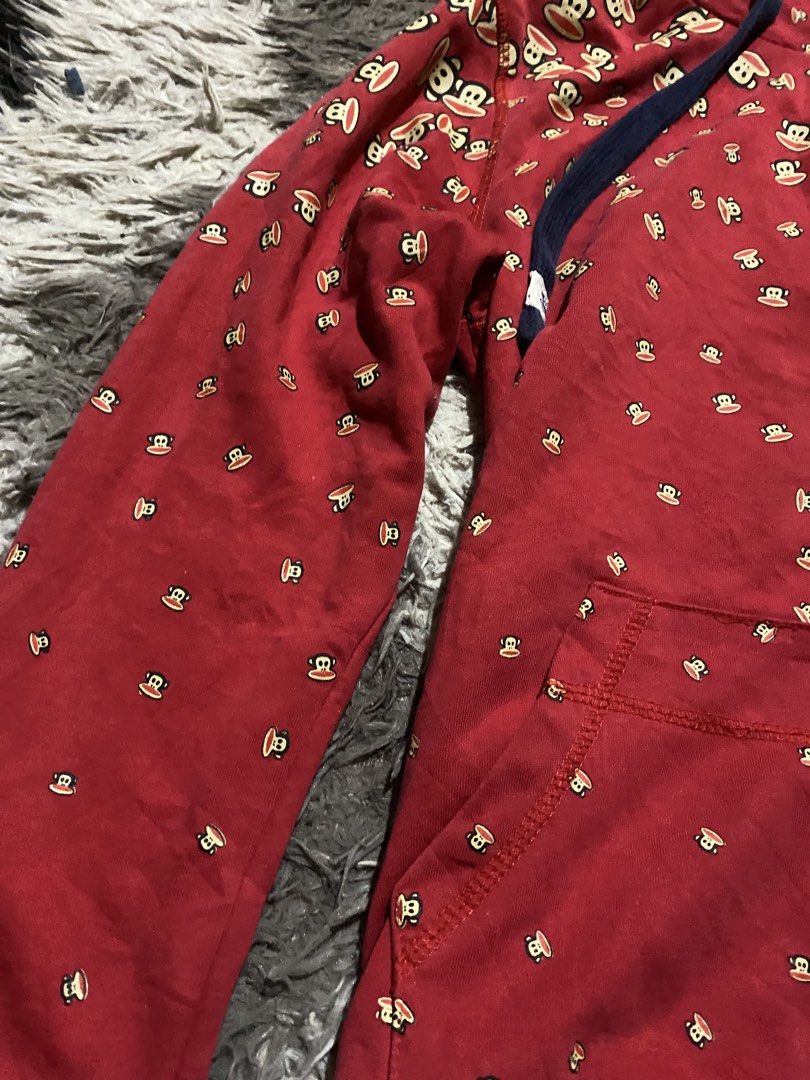 Paul Frank Red Monkey Print Zip-Up Hoodie (Category: Hoodies) located in Caloocan City. Submitted by remythrift (Listing ID 1467785708, Image 3). Description: Red zip-up hoodie covered in Paul Frank monkey graphics all over. Thick navy blue drawstring cords with branded white tips. Matching front kangaroo pockets and ribbed cuffs with a tiny Paul Frank tag on the left wrist. Navy lining inside the hood. Great casual piece for everyday throwing on