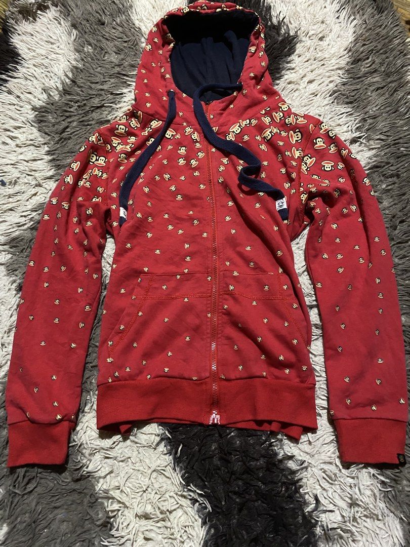 Paul Frank Red Monkey Print Zip-Up Hoodie (Category: Hoodies) located in Caloocan City. Submitted by remythrift (Listing ID 1467785708, Image 1). Description: Red zip-up hoodie covered in Paul Frank monkey graphics all over. Thick navy blue drawstring cords with branded white tips. Matching front kangaroo pockets and ribbed cuffs with a tiny Paul Frank tag on the left wrist. Navy lining inside the hood. Great casual piece for everyday throwing on
