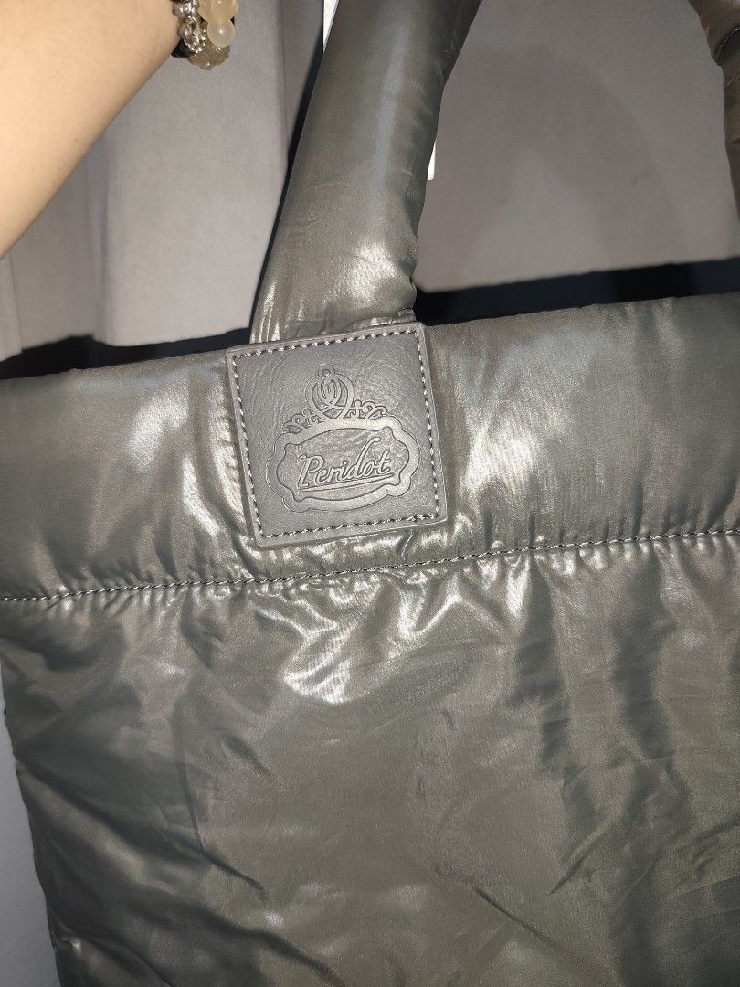 Peridot Puffer Tote Bag Grey (Category: Tote Bags) located in Rizal. Submitted by chicout (Listing ID 1467617564, Image 3). Description: - Brand: Peridot - Color: Grey with black interior lining - Condition: Brand new with original tag attached - Features: Quilted body, comfortable puffy top handles, secure top zipper closure, and an internal open pocket with a leather brand patch - Versatility: Great size for daily use, school, or work .