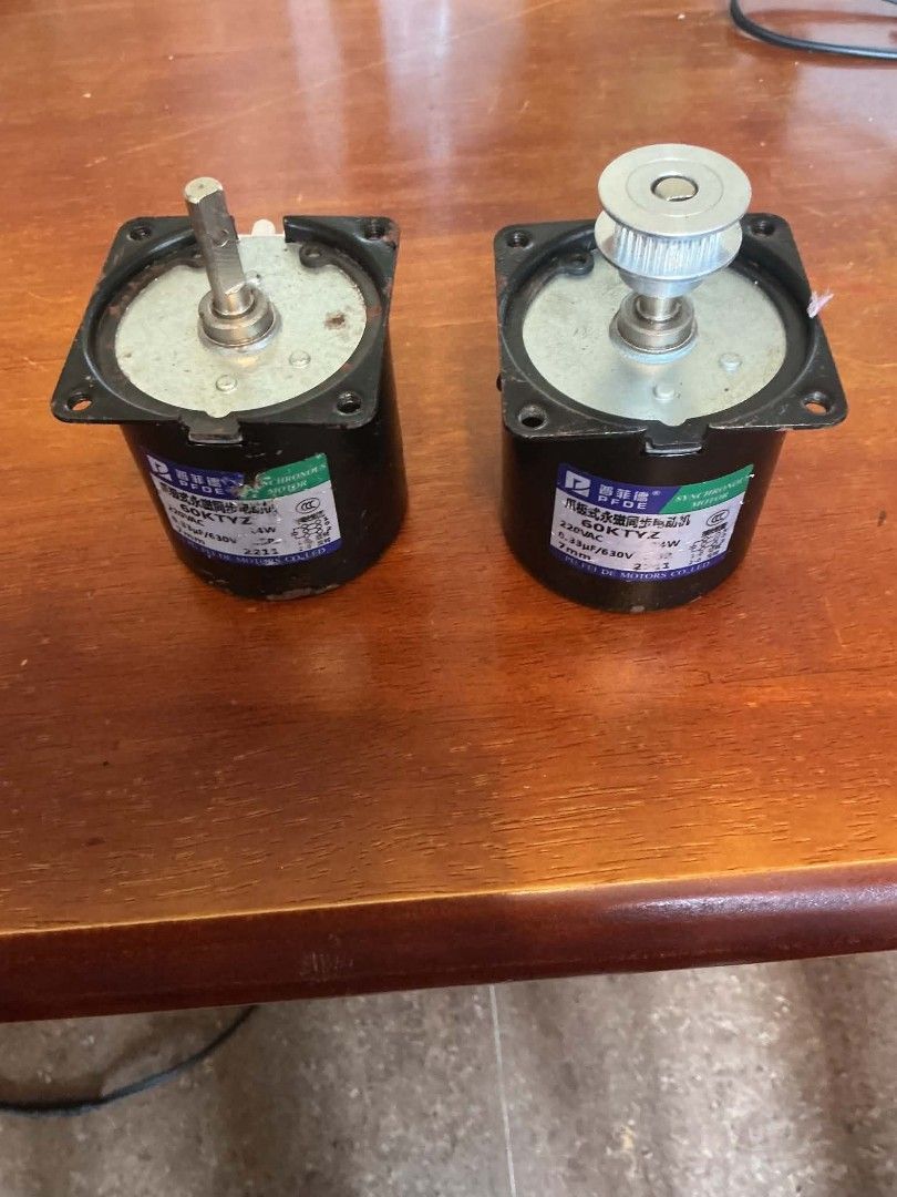 PFDE 60KTYZ Synchronous Motor 220VAC (Category: Industrial Equipment) located in Manila. Submitted by cheapcellphone (Listing ID 1467704672, Image 1). Description: - Item: 2x PFDE 60KTYZ Synchronous Motors - Voltage & Power: 220VAC, 4W - Configuration: One unit with standard shaft, one unit with attached metal pulley - Design: Black cylindrical body with mounting flange plates and clear specification labels - Condition: Great for DIY projects, ho